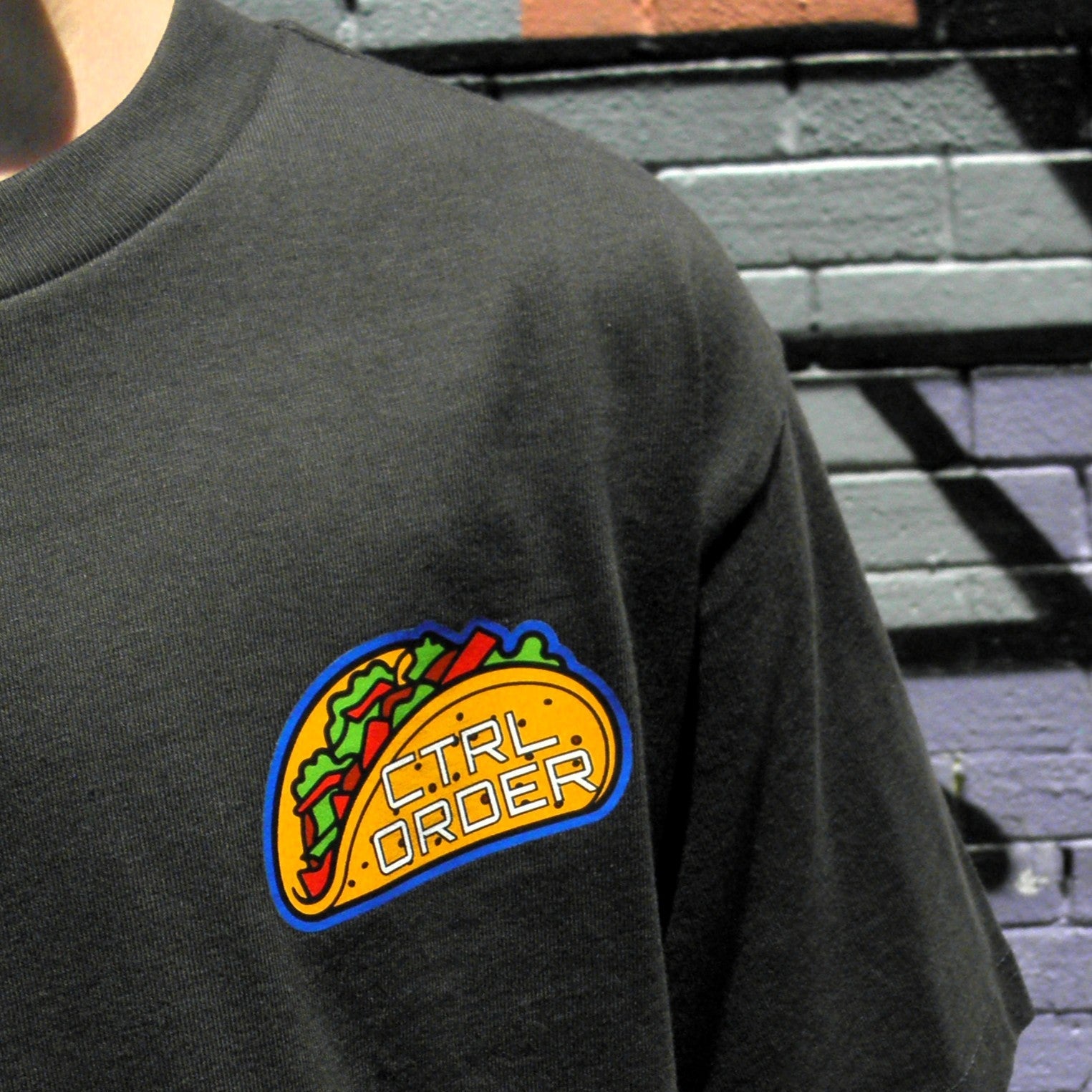 Close-up of Alien Taco chest logo on coal black kids t-shirt - fun youth streetwear by CTRL ORDER Australia