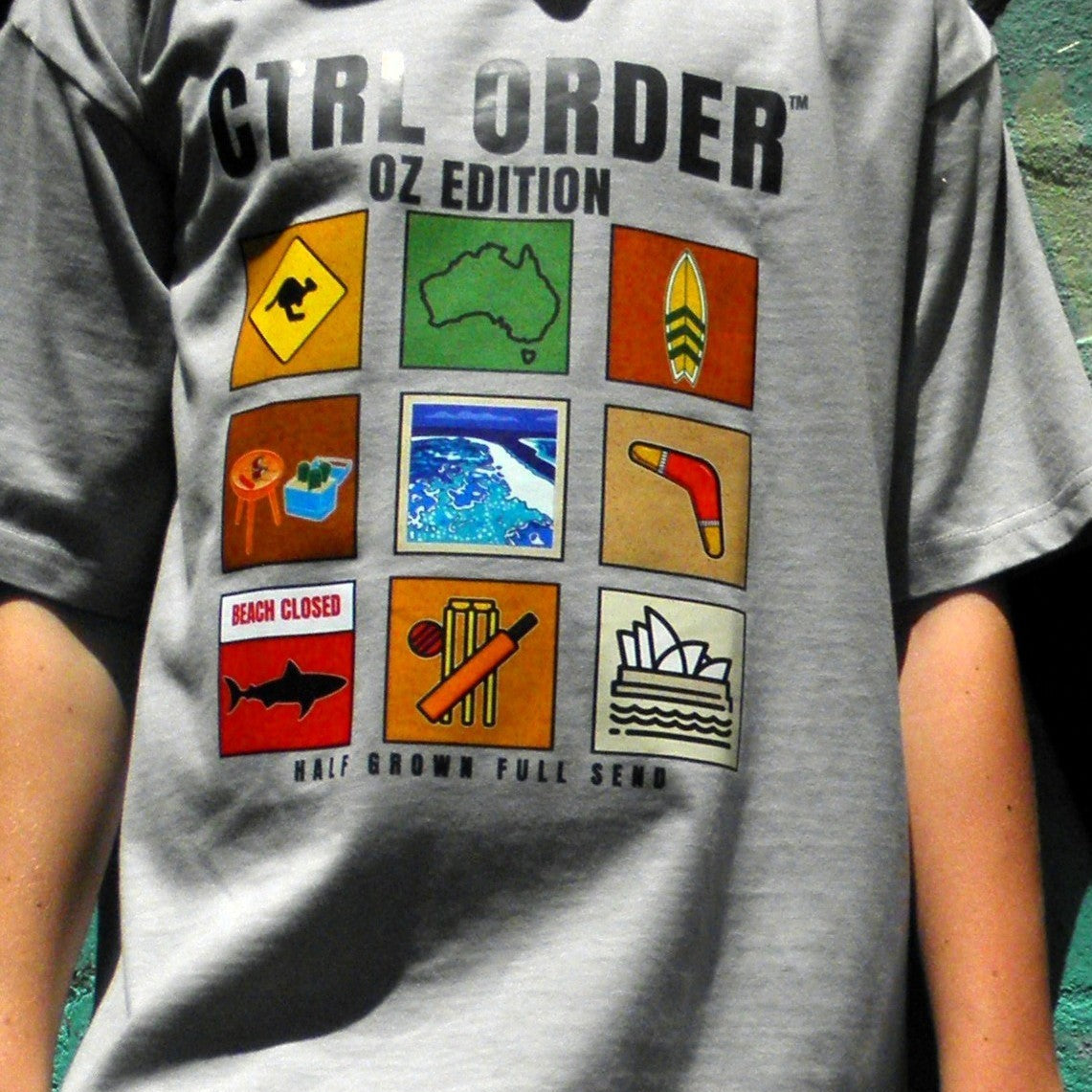 Close-up of CTRL ORDER OZ Edition youth t-shirt graphic on stone colour fabric